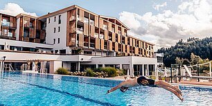 Mann springt in den Außenpool