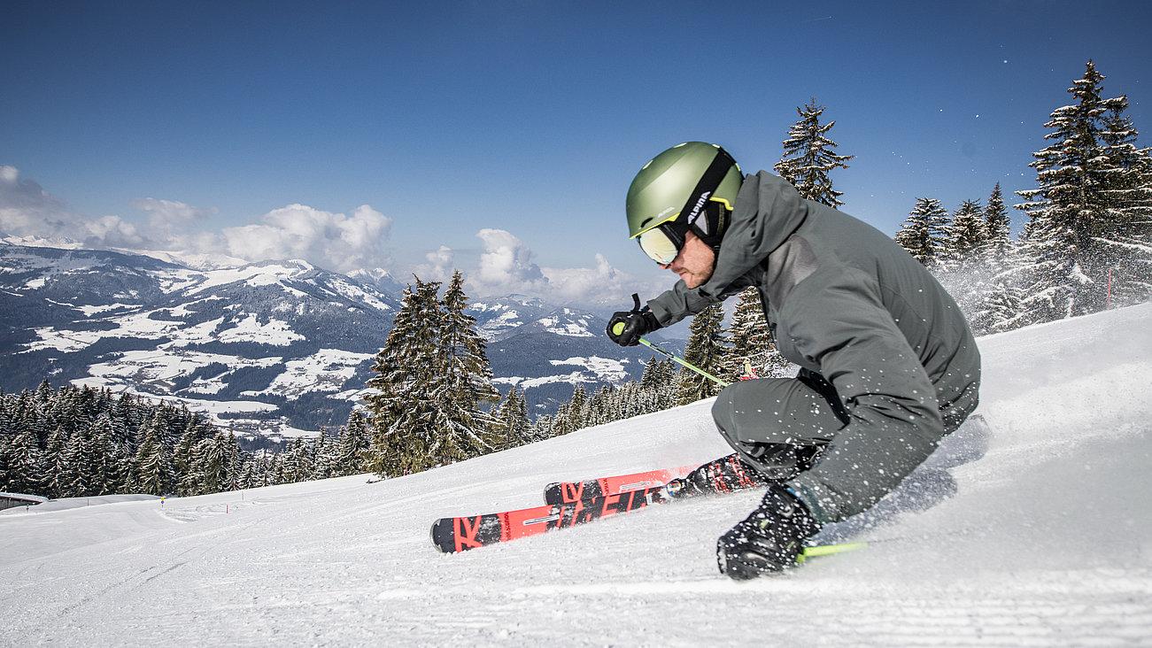 Skifahrer auf der Piste mit Panoramablick auf die Umgebung