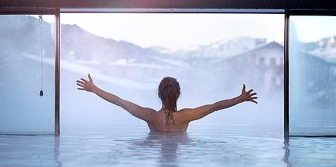 Frau genießt die Aussicht vom Innenpool aus