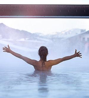 Frau genießt die Aussicht vom Innenpool aus