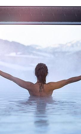 Frau genießt die Aussicht vom Innenpool aus