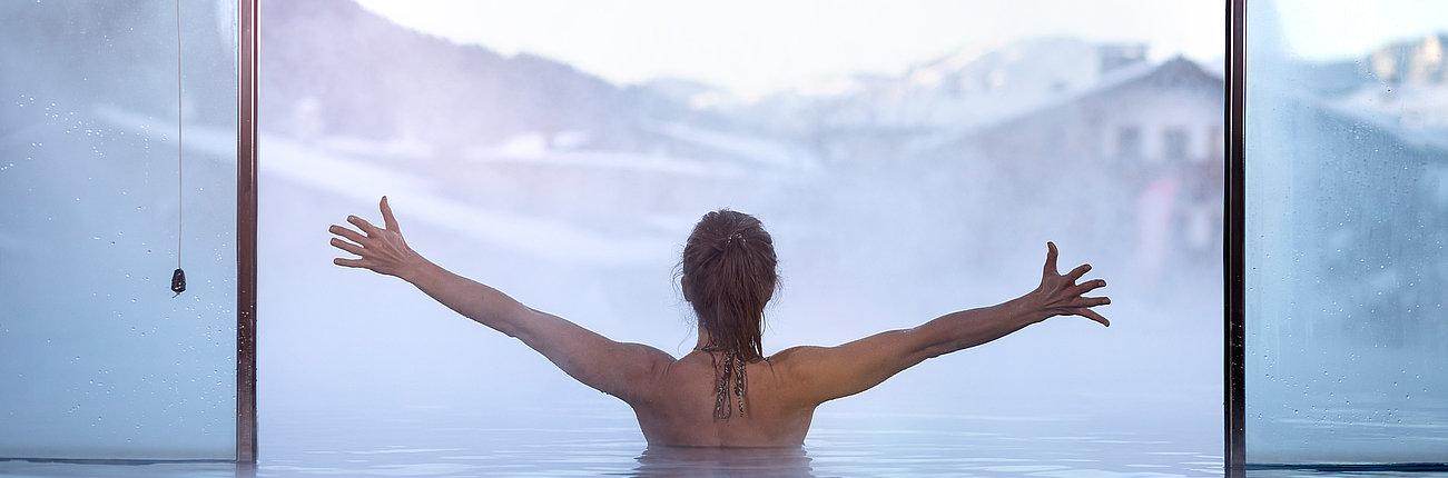 Frau genießt die Aussicht vom Innenpool aus