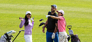 Golfergruppe unterhält sich am Rasen