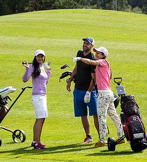 Golfergruppe unterhält sich am Rasen