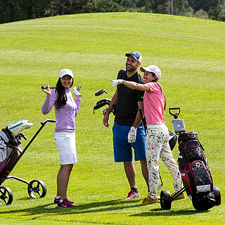 Golfergruppe unterhält sich am Rasen