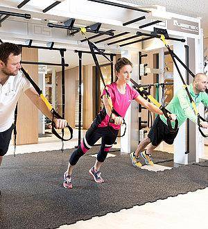 Trainer zeigt zwei Sportlern Übungen