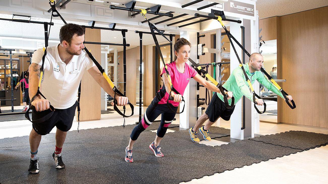 Trainer zeigt zwei Sportlern Übungen