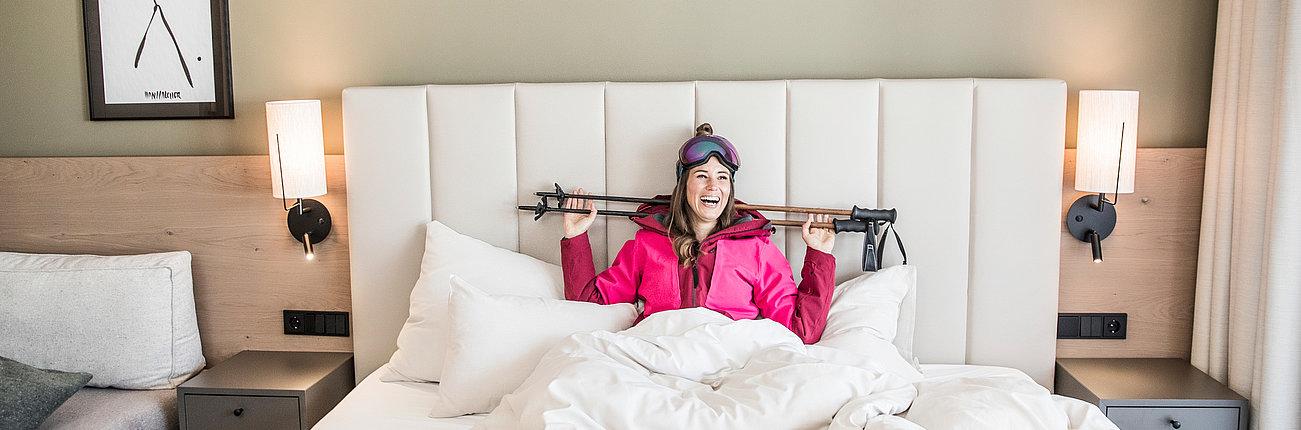 Gast im Skifahrer-Outfit im Bett