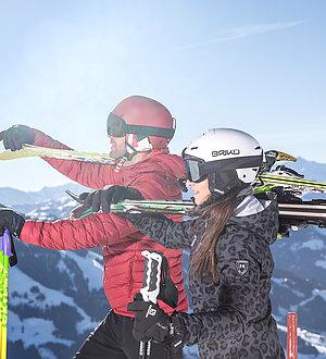 Skifahrer genießen die Aussicht mit geschulterten Skiern