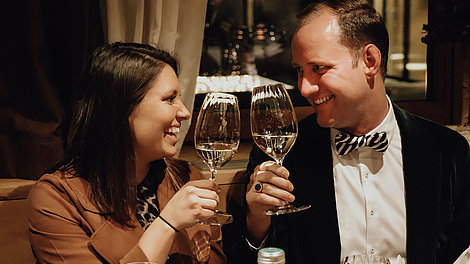 Mann und Frau stoßen mit Weißwein an