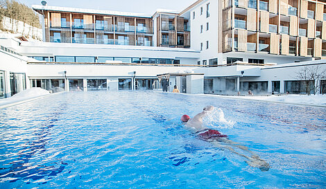 Schwimmer im Außenpool schwimmt eine Bahn